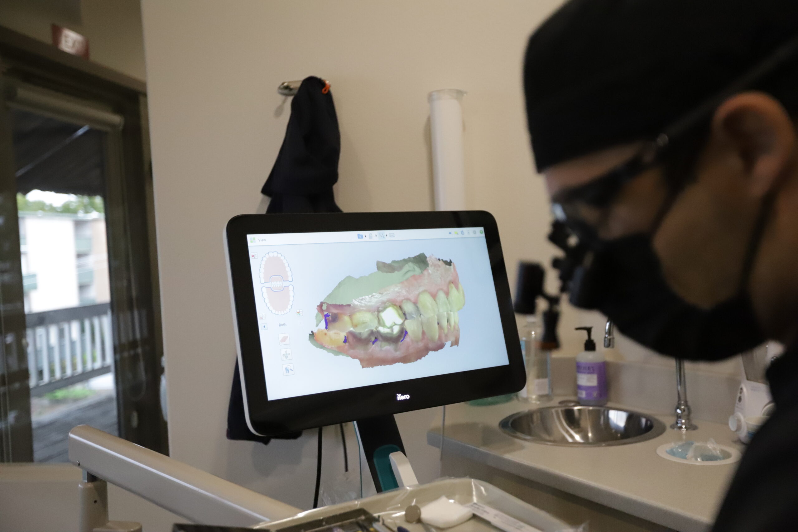 Dentist examining a patient's jaw and back molars at Milcovich Dental Arts